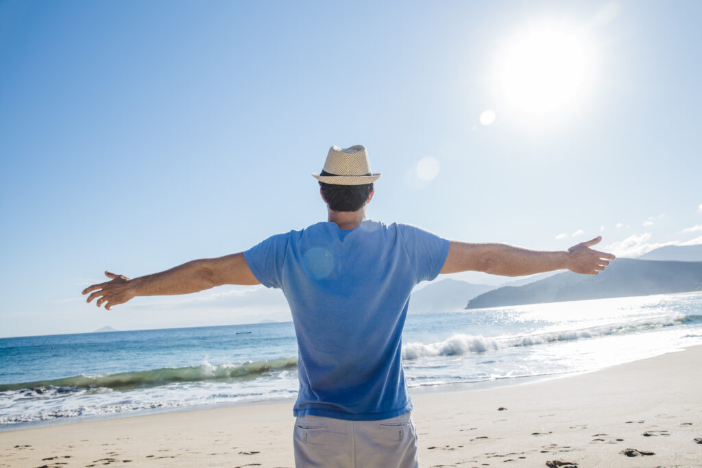 man stretching arms beach scaled